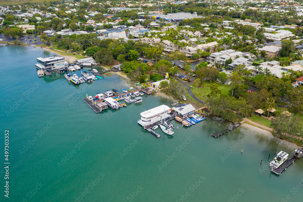 Aerial view of boats tied up at jettys along the river bank of a coastal town Aerial view of boats tied up at jettys along the river bank of a coastal town