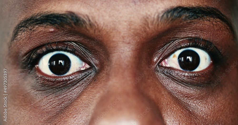 Extreme face close-up, macro eyes of black African man looking sideways Extreme face close-up, macro eyes of black African man looking sideways