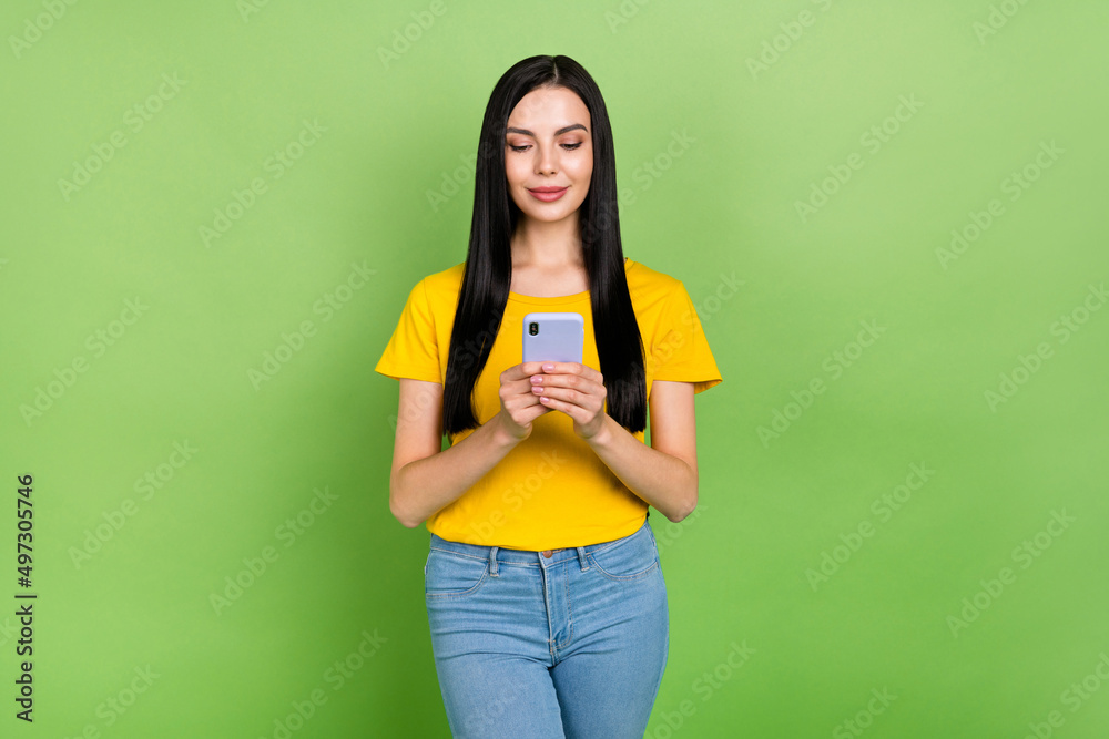 Photo of pretty sweet woman wear yellow t-shirt smiling typing modern device isolated green color background Photo of pretty sweet woman wear yellow t-shirt smiling typing modern device isolated green color background