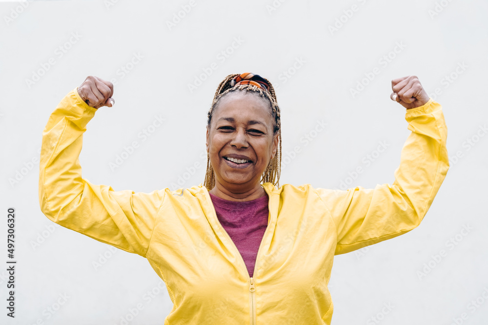 Naklejka premium Senior African woman doing exercise workout routine outdoor - Focus on face