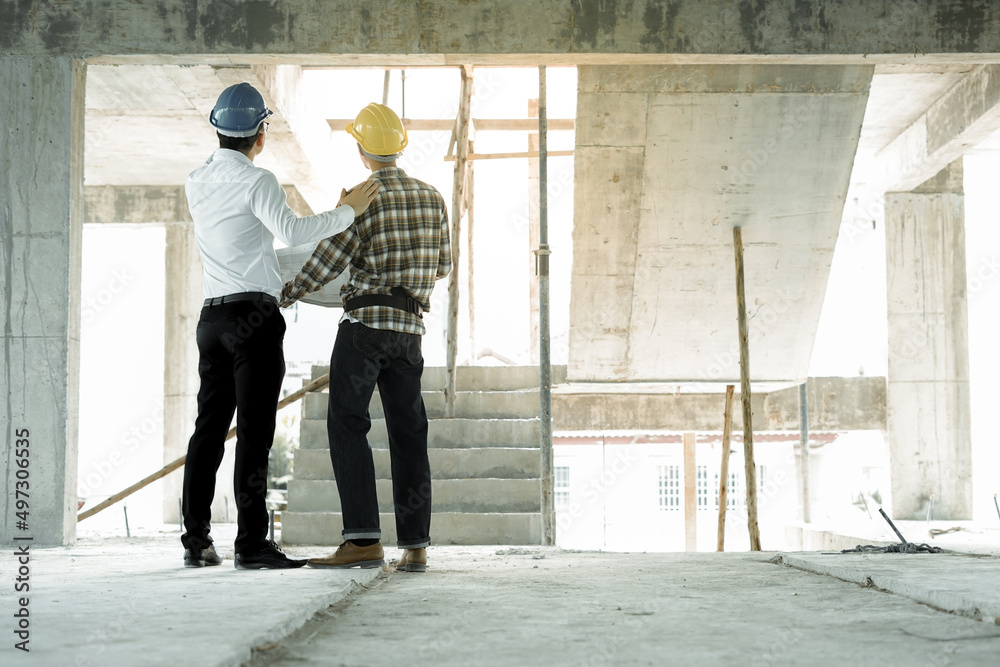 Civil engineers inspector and worker discussing meeting inspect audit and advice about house building or real estate project with blueprint in construction site as Engineering concept