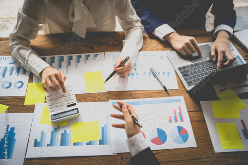 Managers are using report to analyze sales cost reports and explain summary reports to employees calculate and record summary information data in the office. photo
