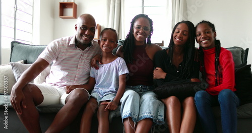 Black African family posing together for photo at home couch