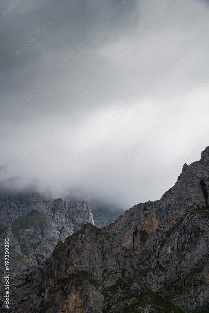 Imposing and majestic sharp limestone peaks stand tall amidst the fog
