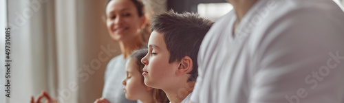 Cropped head of smiling woman watching her husband and kids doing mental practice at home together