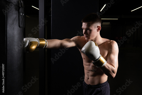 Athlete bag boxer practices The blows the glove black young male boxing, from muscular fighter for combat from caucasian hit, shadow martial. Athletic victory dark,