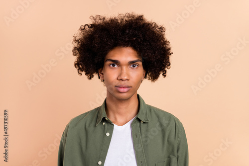 Portrait of attractive content cute guy with well-groomed hairdo isolated over beige pastel color background
