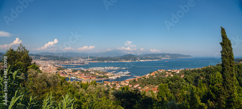 Sunny panoramic view of the city and the bay, port for ships from the distance. Tourism and transport. Rest and travel. Summe day.