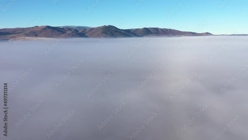 Flying over mist and clouds in a sunny morning. Aerial drone view Flying over mist and clouds in a sunny morning. Aerial drone view