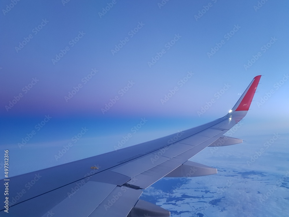 Airplane wing in the blue sky