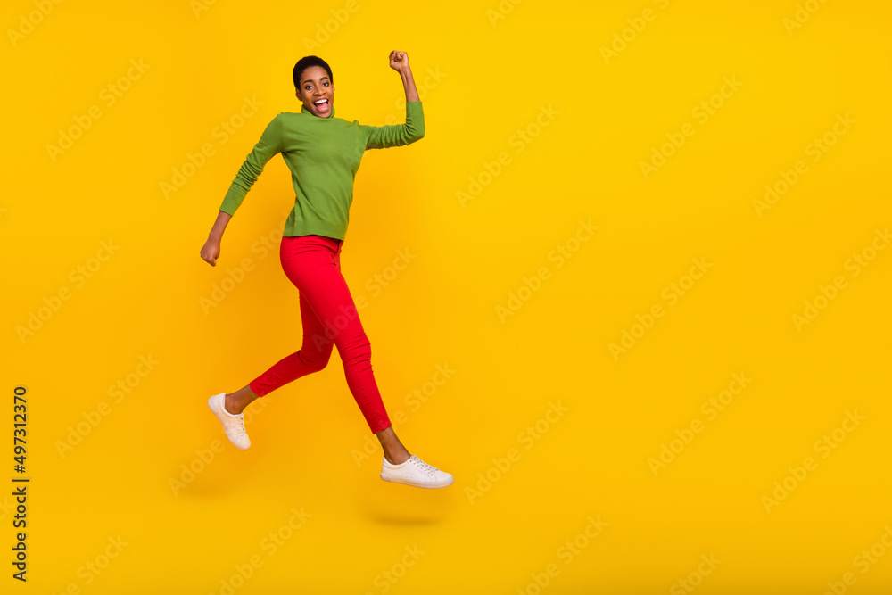 Photo of pretty charming short hair lady dressed green turtleneck running fast jumping high isolated yellow color background