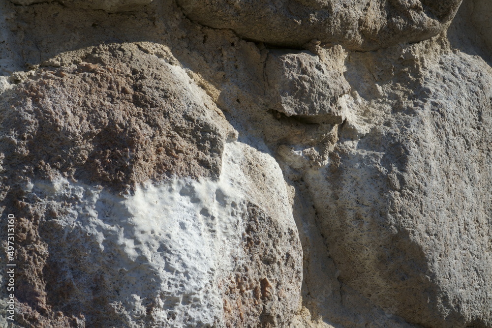 An efflorescence effect sample - salt deposits on stone masonry. A close-up view of a boulder wall in a historical building. The castle ruins stone construction fragments in macro with salt sediments.