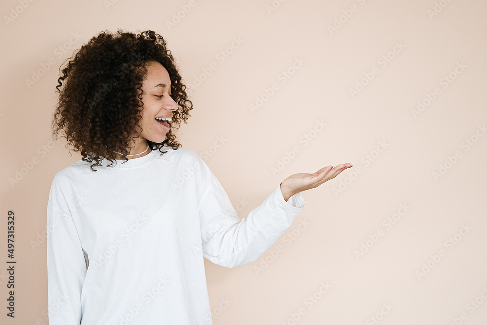 Young african american woman over isolated background smiling cheerful presenting and pointing with palm of hand looking at the camera. Your advertising here Young african american woman over isolated background smiling cheerful presenting and pointing with palm of hand looking at the camera. Your advertising here