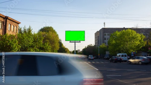 Wallpaper Mural 4K Time Lapse video. A billboard with a green screen on a background of city traffic with cars, walking people, trees, blue sky Torontodigital.ca