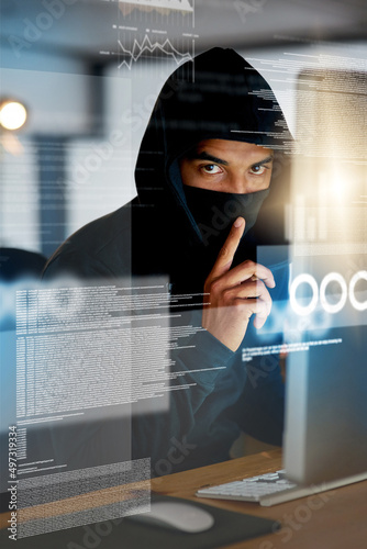 You wont even notice its gone. Portrait of a serious computer hacker hacking into a computer in an office.