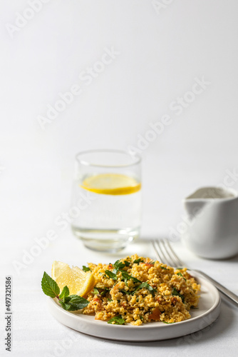 famous tabule salad with chopped parsley ,vegetables and bulgur , served with dressing mad olive oil and lemon juice on the table.