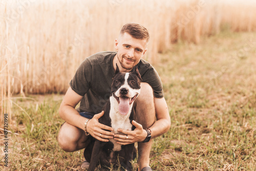 Man with his dog hugging and playing outdoor in the park.