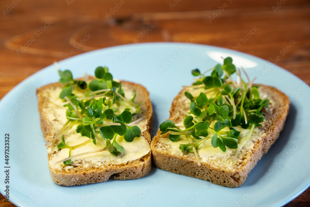 Set sandwiches for breakfast. Sandwiches with micro greens on blue plate on wooden background, tasty and fresh organic food healthy breakfast snack concept