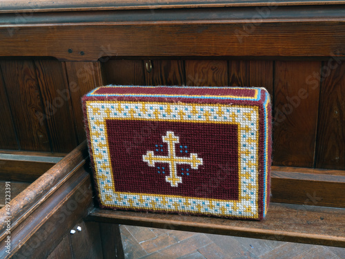 Church kneeler on wooden pew, for Christian prayer.