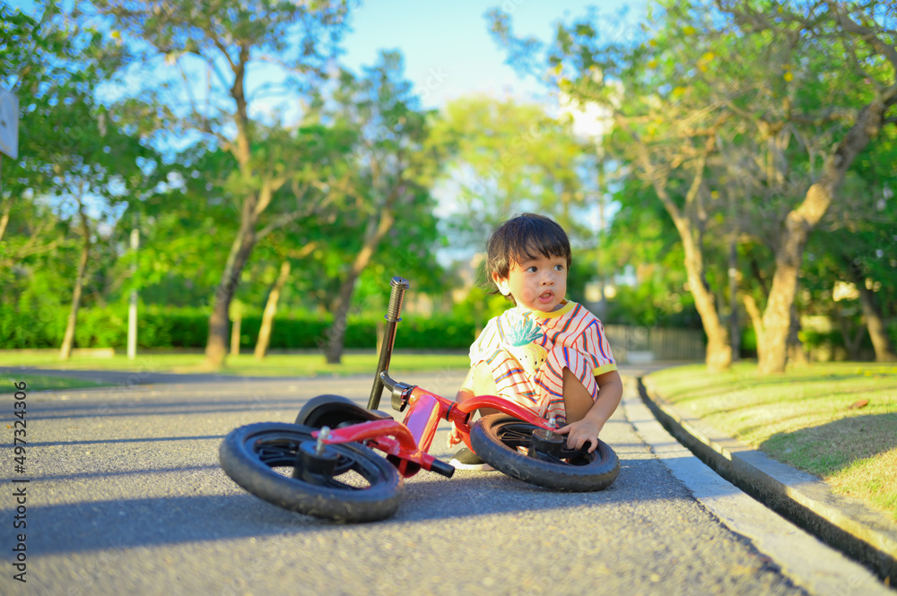 Asian boy about 2 years is riding baby balance bike and fall, learning concept Asian boy about 2 years is riding baby balance bike and fall, learning concept