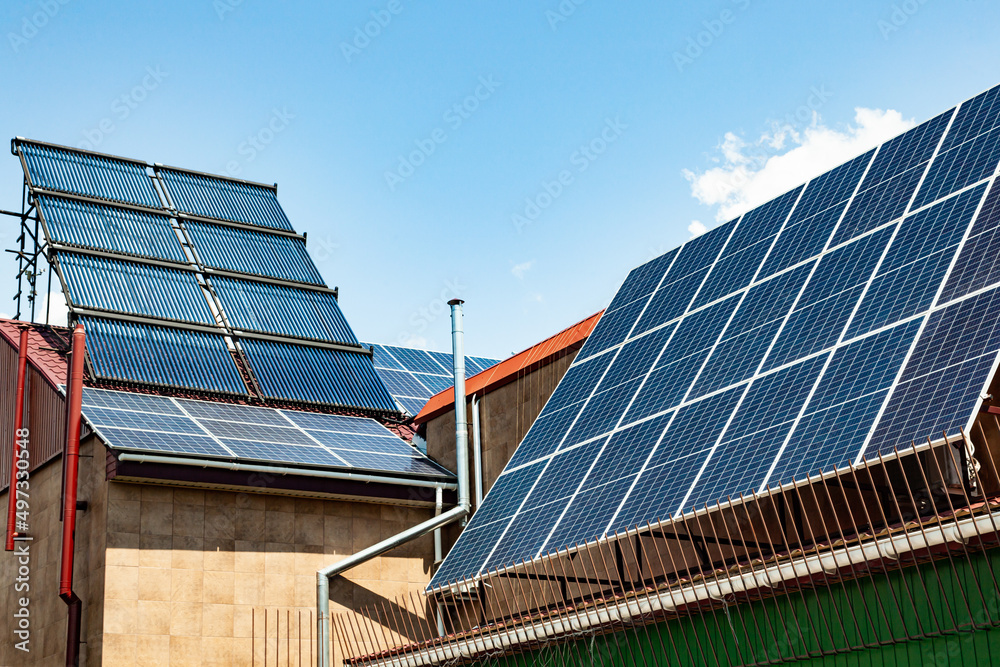 Fototapeta premium The roof of an energy efficient home with solar panels and solar water heaters.