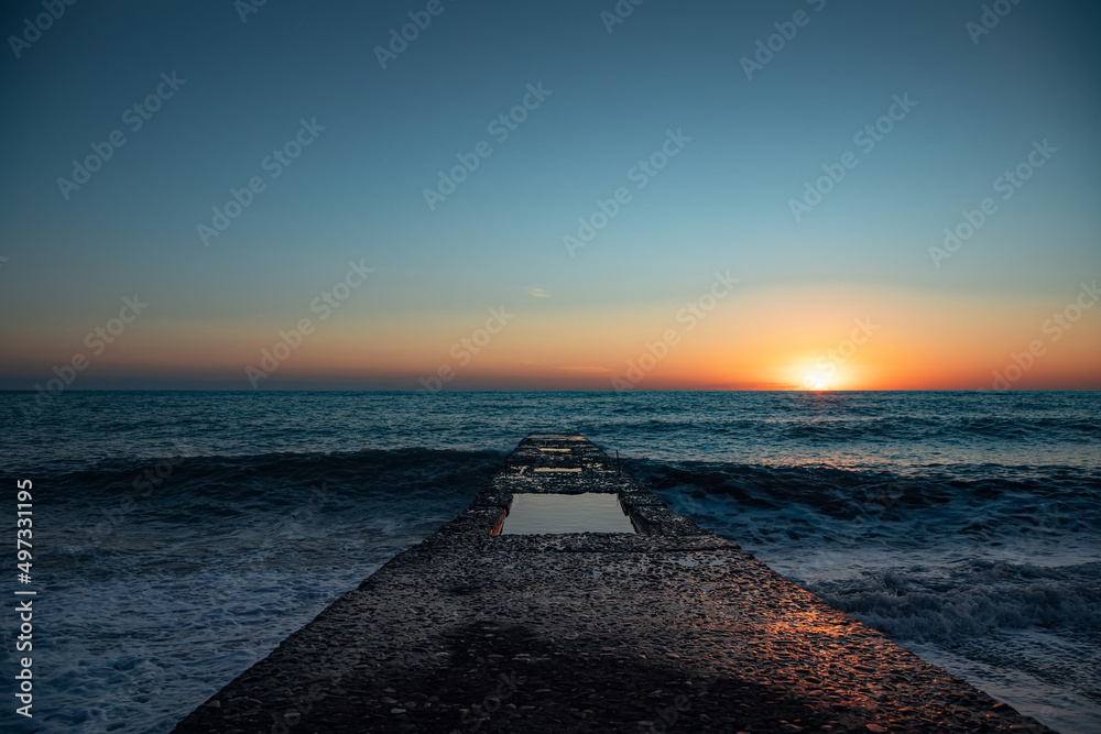 The coastline. Sea sunset. The Black Sea. Concrete pier. Twilight.