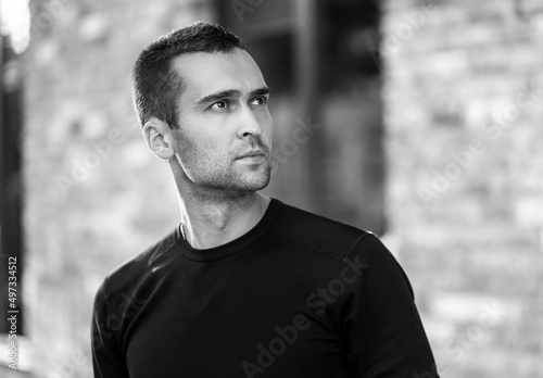 handsome man with short bristles in a black t-shirt. Portrait