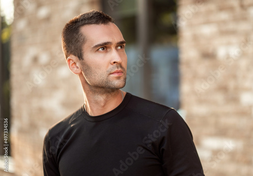 handsome man with short bristles in a black t-shirt. Portrait