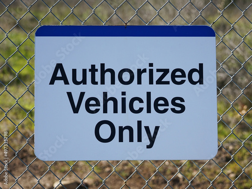 Authorized vehicles only warning sign on chain link fence.