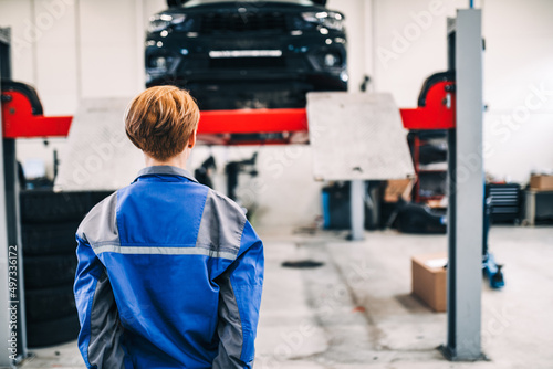 A professional female mechanic working in a car service.