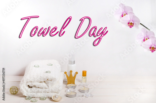 Towel day lettering, white towel with pink hearts on a white wooden background