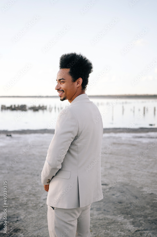 Young African American man groom looks into the camera. Portrait at sunset in nature Young African American man groom looks into the camera. Portrait at sunset in nature