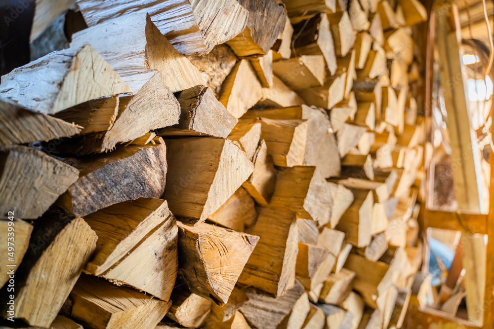 Chopped and chopped firewood stacked and harvested for the winter in a firewood shed. Storing firewood in summer Chopped and chopped firewood stacked and harvested for the winter in a firewood shed. Storing firewood in summer