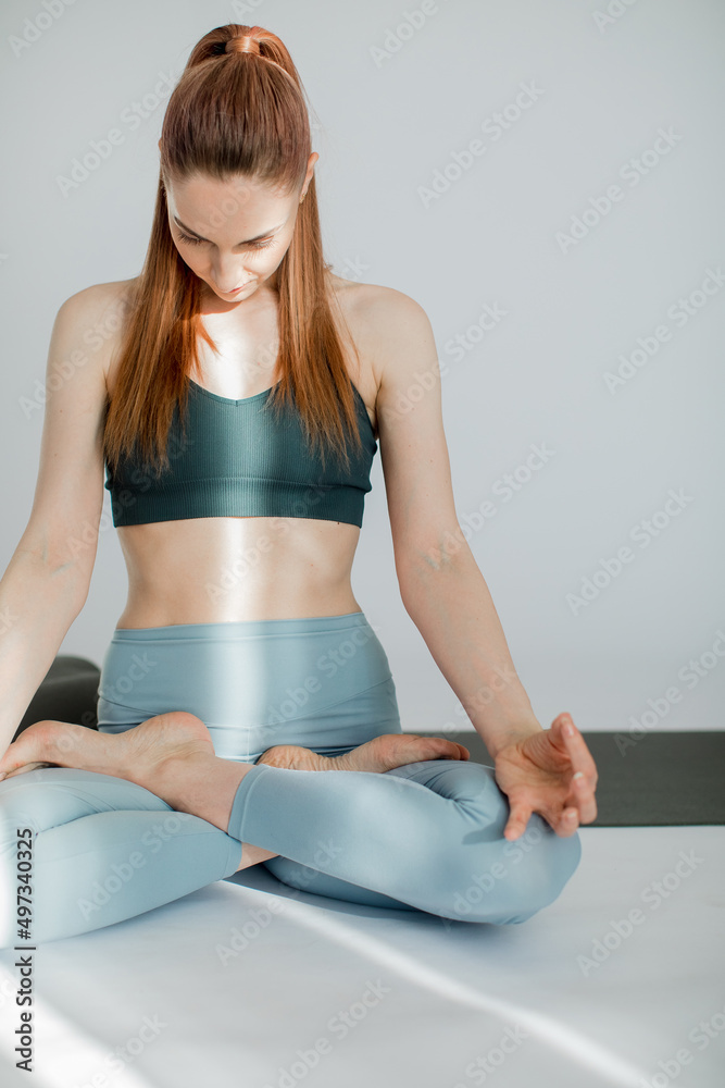 a young girl sits in a lotus position and meditates, her hands are folded in mudra, sunbeam shine on her body a young girl sits in a lotus position and meditates, her hands are folded in mudra, sunbeam shine on her body