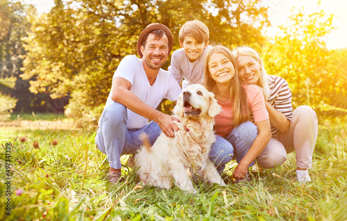 Familie mit Sohn und Tochter und Hund im Garten