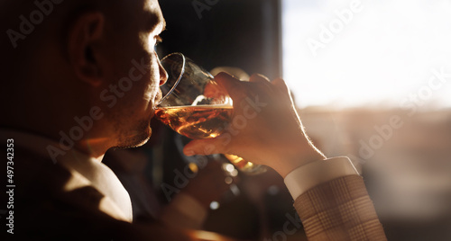 Canvas Print man in suit drinking beer by the window. High quality photo