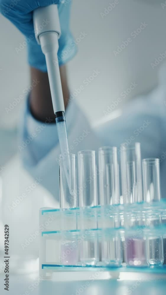 Vertical Video. Medical Development Laboratory: Scientist Uses Micro Pipette to Mix Petri Dish Test Sample and Analyze it Under Microscope. Medicine, Biotechnology, Vaccine Research in Lab Vertical Video. Medical Development Laboratory: Scientist Uses Micro Pipette to Mix Petri Dish Test Sample and Analyze it Under Microscope. Medicine, Biotechnology, Vaccine Research in Lab