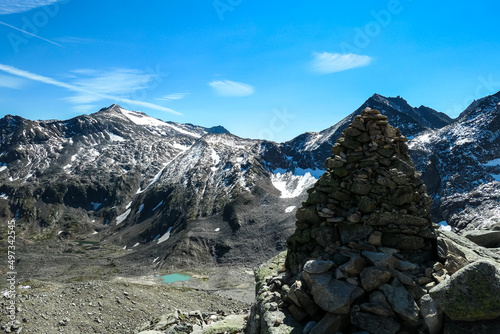 Pile of stone with panoramic view on a glacier lake near Hoher Sonnblick in the mountains of High Tauern Alps in Carinthia, Salzburg, Austria, Europe. Goldbergkees in Hohe Tauern National Park. Cairn photo