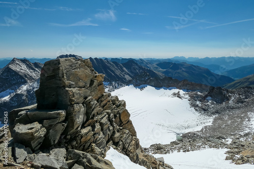 Rock formation with scenic view on Hoher Sonnblick glacier in High Tauern mountains in Carinthia, Salzburg, Austria, Europe, Alps. Goldbergkees in Hohe Tauern National Park on a sunny day. Melting ice photo