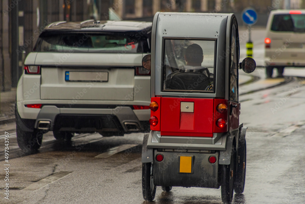 Small electric car in streets of Zurich town in rainy spring day