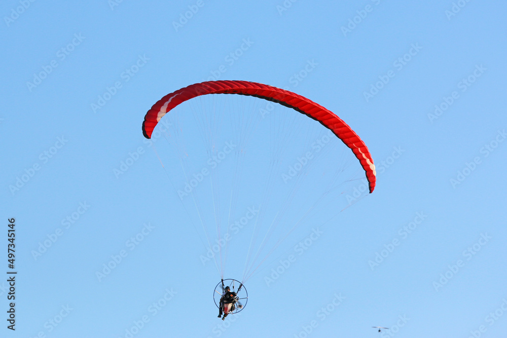Paramotor pilot flying in a blue sky
Paramotor pilot flying in a blue sky