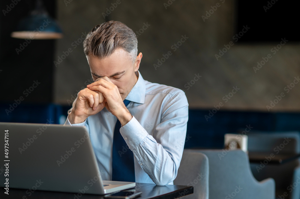 A businessman feeling tired after long work