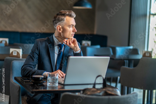 Wallpaper Mural A mid aged businessman sitting at the laptop and thinking Torontodigital.ca