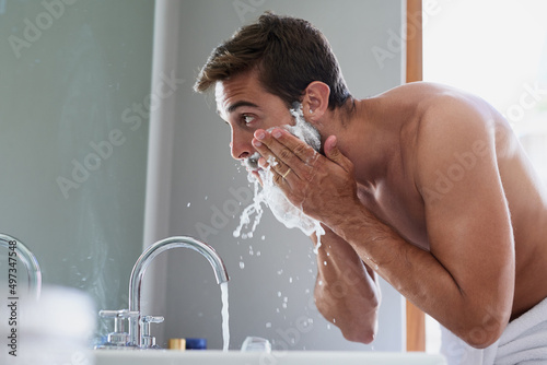Start your day with a splash. Cropped shot of a handsome young man in his bathroom.