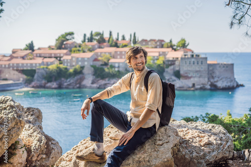 Man tourist on background of beautiful view of the island of St. Stephen, Sveti Stefan on the Budva Riviera, Budva, Montenegro. Travel to Montenegro concept