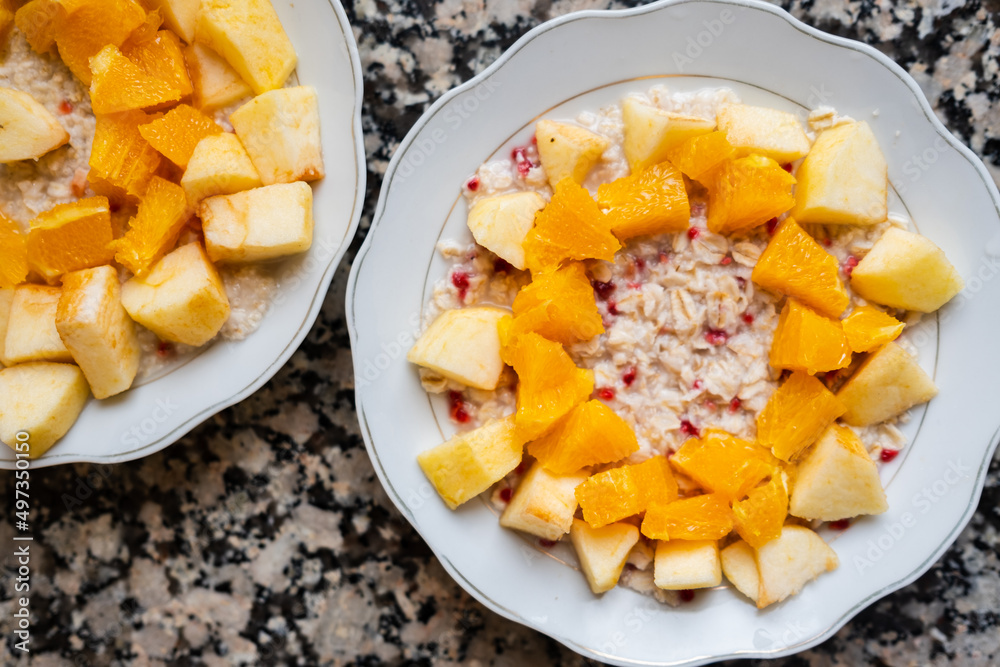 Useful breakfast. Oatmeal porridge with oranges and apples in a bowl. High quality photo Useful breakfast. Oatmeal porridge with oranges and apples in a bowl. High quality photo