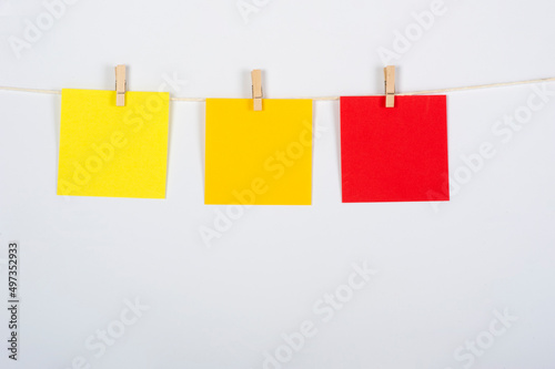 Tres postiks verdes colgados para ejercicio, de color amarillo, naranja y rojo para estrategia o trabajo en equipo, conceptos a tratar.