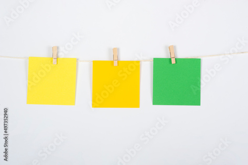Tres post its colgados para ejercicio, amarillo, naranja y verde para estrategia o trabajo en equipo, conceptos a tratar.