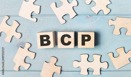 Blank puzzles and wooden cubes with the text BCP Business Continuity Plan lie on a light blue background.