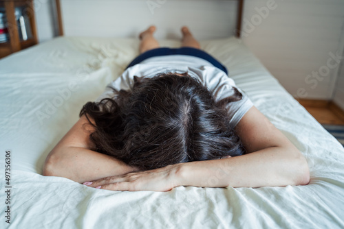 Sad, unhappy woman lying on bed in depression. Headache,stress,anxiety,tension,psychological problems. Poor mental health,visiting psychologist,psychotherapy session.Worries about work,family divorce